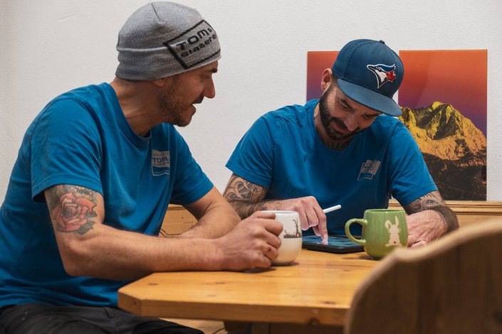 Zwei Männer schreiben bei einem Kaffee ihre Ideen auf