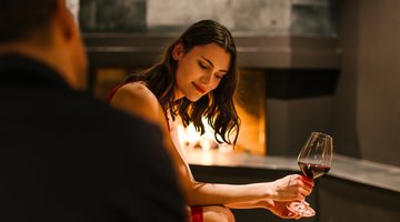 A brunette in front of the fireplace with a sensual look