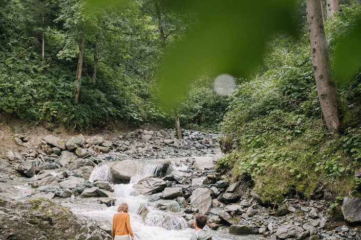 Paar wandert am Gebirgsbach entlang