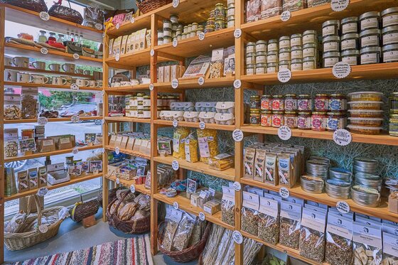 Hofladen mit regionalen Produkten Holzregale in einem Hofladen mit regionalen Produkten wie Honig, Nudeln, Eiern und Gläsern.
