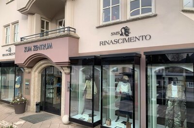 Außenansicht des Bekleidungsgeschäfts Rinascimento mit Schaufenstern und Mannequins.