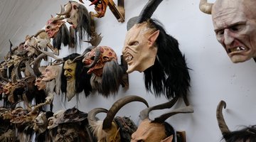 Mehrere Krampusmasken an einer Wand