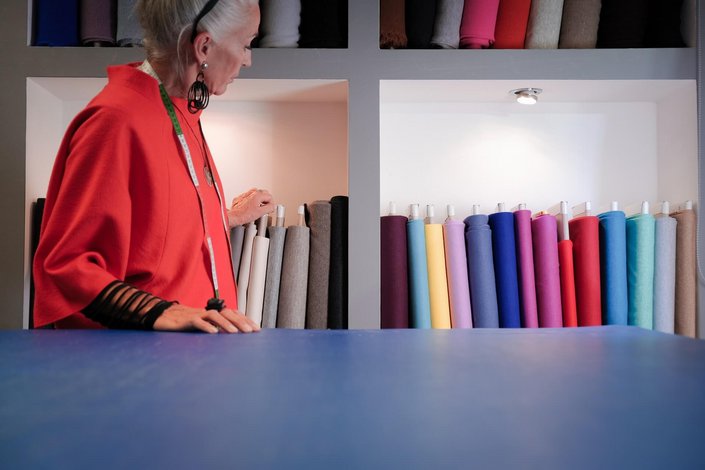 Frau mit Stoffen im Hintergrund