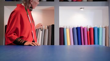 Frau mit Stoffen im Hintergrund