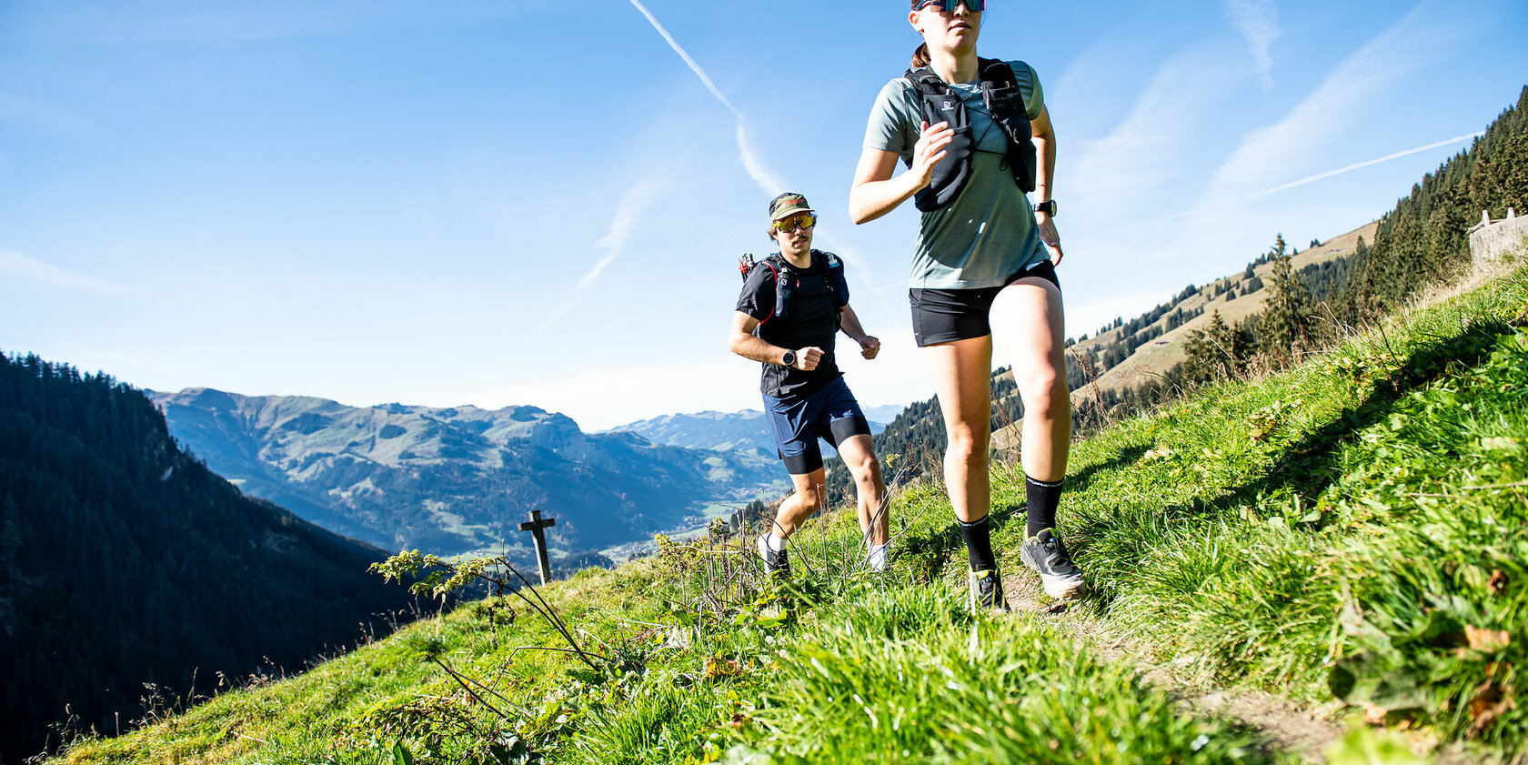 Die beiden Jogger scheinen motiviert und konzentriert, während sie die atemberaubende Aussicht auf die Berge genießen.