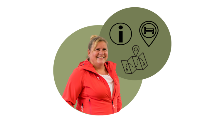 Eine Kitzbühel Tourismus Mitarbeiterin im roten Hoodie lächelt