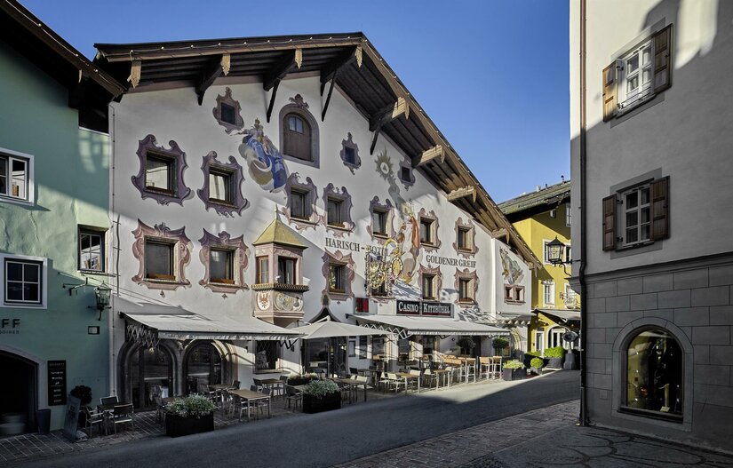Hotel Goldener Greif Außenansicht Fassade des Hotels Goldener Greif mit Wandmalereien und Außengastronomie in einer gepflasterten Gasse.