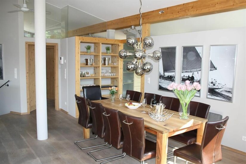 Suiten am Schloss Penthouse Essbereich Moderner Essbereich mit Holztisch, Lederstühlen und einer auffälligen Kugelleuchte.