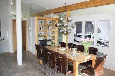 Suiten am Schloss Penthouse Essbereich Moderner Essbereich mit Holztisch, Lederstühlen und einer auffälligen Kugelleuchte.