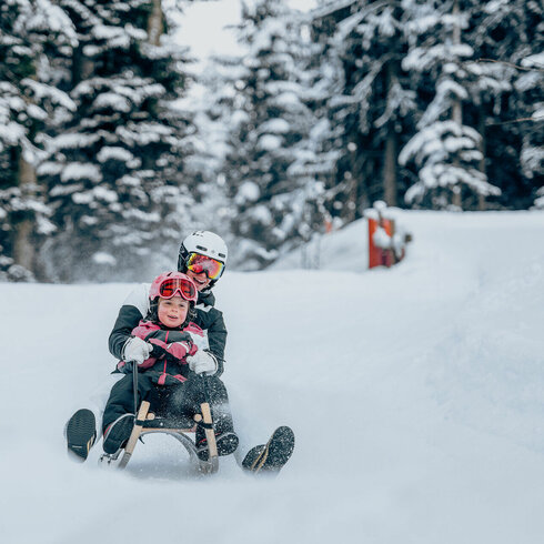 The family is sledding in Kitzbühel and having fun