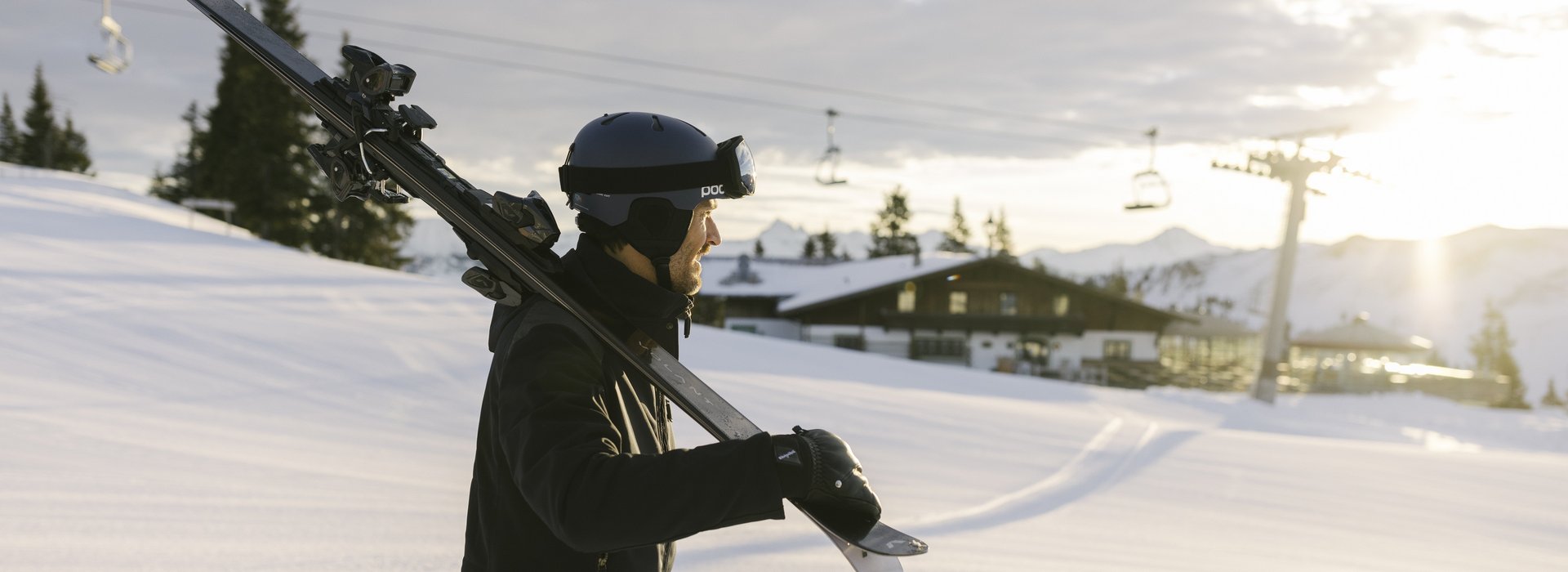 Man carries his skis towards the slope