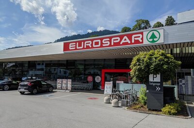 Eurospar Supermarkt Außenansicht eines Eurospar-Supermarktes mit Parkplatz und Fahrrädern vor dem Eingang.