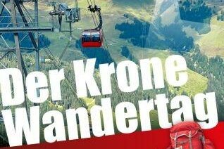 Rote Seilbahngondel vor bewaldeten Bergen mit Wanderausrüstung im Vordergrund.