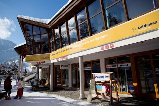 Hornplatzl Winter Außenansicht eines Skigeschäfts mit Glasfront und Holzfassade im Winter.