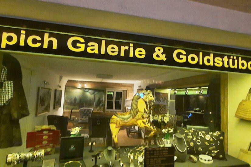 Goldstübchen Ein Schaufenster mit der Aufschrift „Teppich Galerie & Goldstückchen“. Die Ausstellung zeigt Schmuck und Accessoires.
