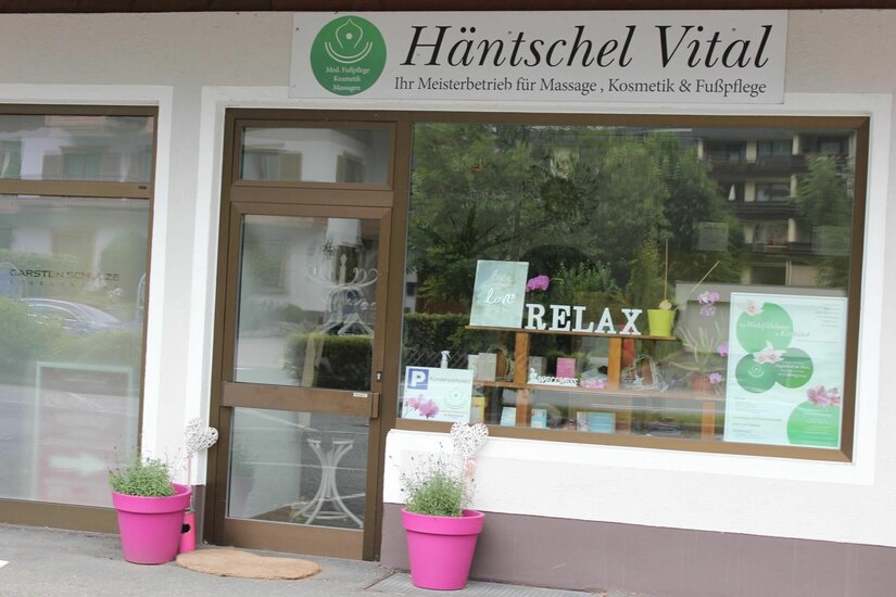 Häntschel Vital Eingangsbereich Außenansicht des Geschäfts Häntschel Vital mit Schaufenster und pinken Blumentöpfen.