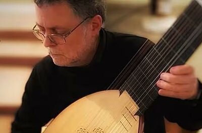Eine musikalische Darbietung auf einer Bühne mit vier Musikern. Das Publikum applaudiere und genießt die Aufführung.
