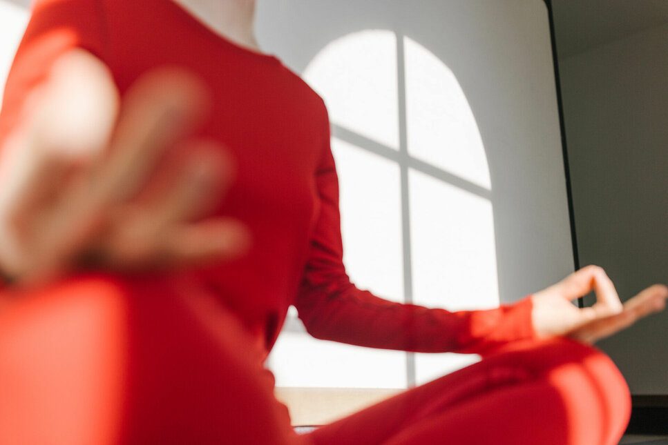 Woman in red workout clothes doing yoga in Kitzbühel—for beginners and advanced practitioners