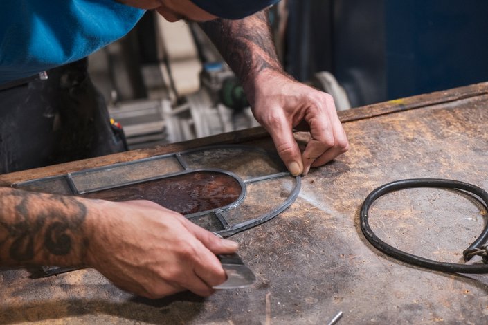 Ein Mann beim Arbeiten am Glas in einer Glaserei