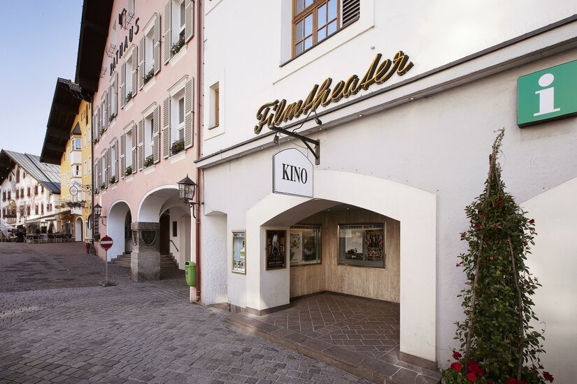 Eingangsbereich des Filmtheaters Kitzbühel in einer gepflasterten Straße neben dem Rathaus.