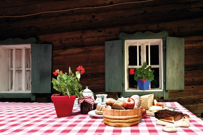 Jausentisch vor altem Holzhaus