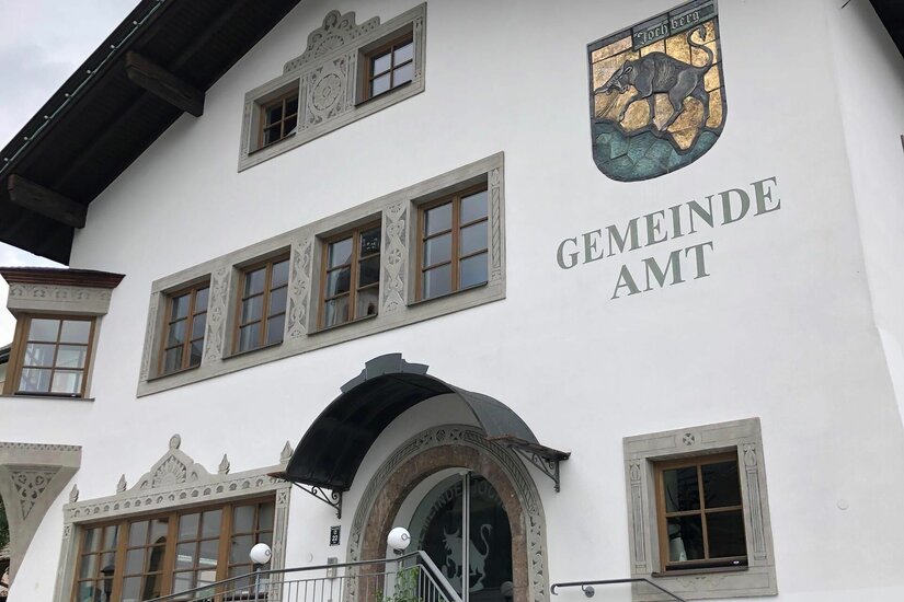 Gemeindeamt Jochberg Weiße Fassade des Gemeindeamts Jochberg mit Wappen und Schriftzug.