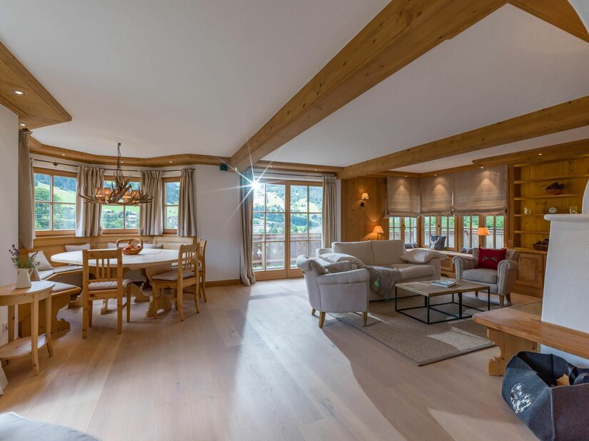 Wohnbereich im Haus Schmidt Heller Wohnraum mit Holzbalkendecke, Sitzecke, Sofa und Esstisch aus Holz.