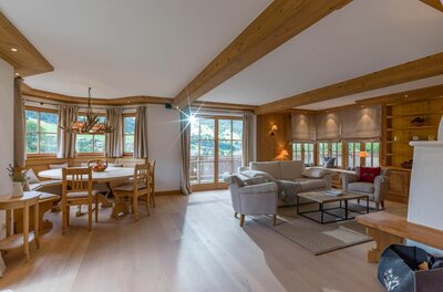 Wohnbereich im Haus Schmidt Heller Wohnraum mit Holzbalkendecke, Sitzecke, Sofa und Esstisch aus Holz.