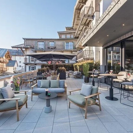 Sonnige Terrasse mit geschmackvoller Einrichtung, die eine entspannte Atmosphäre inmitten der Kitzbüheler Alpen schafft.