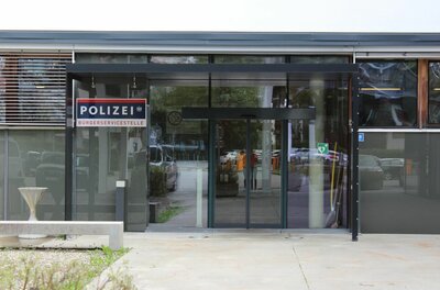 Polizeiinspektion Bürgerservicestelle Eingangsbereich einer Polizeistation mit Glasschiebetür und Schild Bürgerservicestelle.