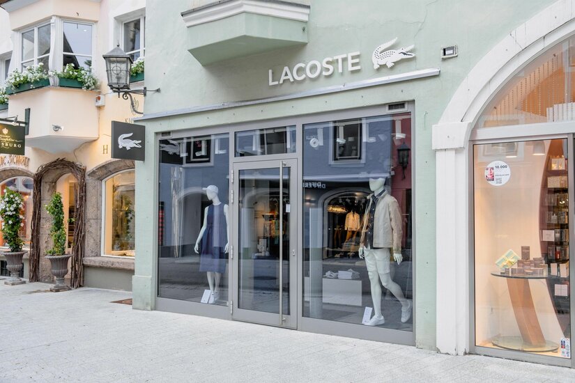 Lacoste Ladengeschäft Außenansicht eines Lacoste-Modegeschäfts in einer gepflasterten Fußgängerzone mit Schaufensterpuppen.