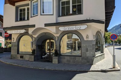 Geschäft Die Wohnidee Außenansicht des Geschäfts Die Wohnidee mit Rundbogenfenstern und Steinfassade an einer Straßenecke.