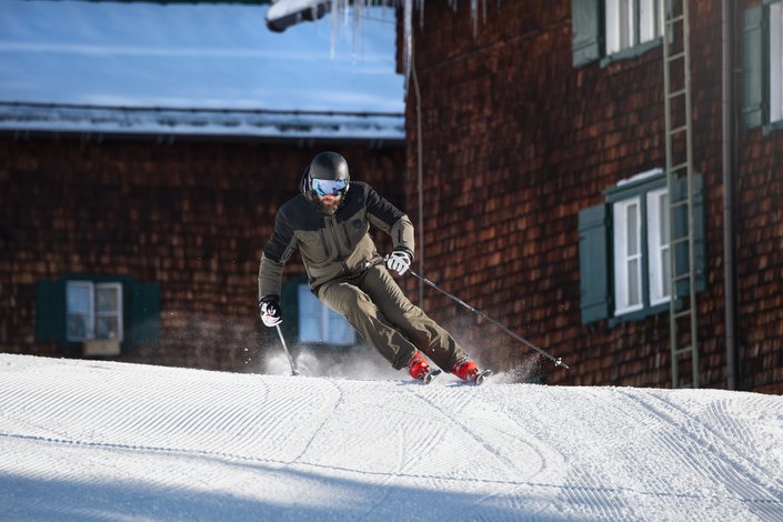 Man skiing in front of ski hut