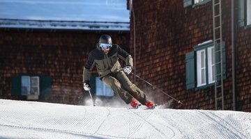 Man skiing in front of ski hut