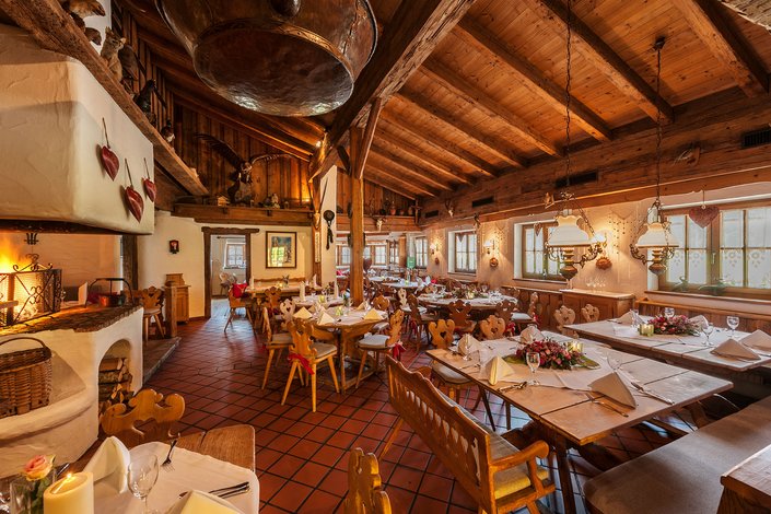 s'Pfandl Innenausstattung aus Holz mit traditionellem Ofen, Kaffeegeschirr, Geweih und Bilder