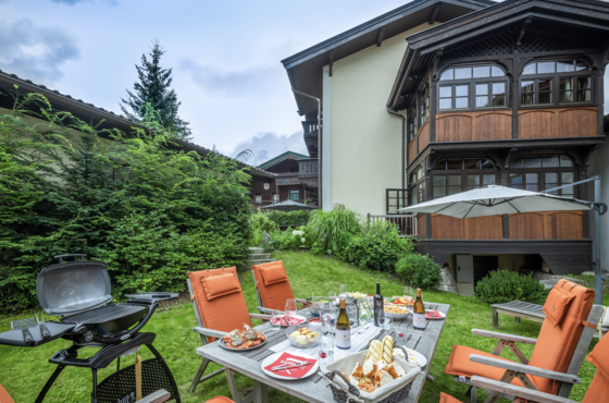 Gartenbereich der Altstadtvilla Gedeckter Holztisch mit Speisen und Getränken in einem Garten neben einem Gasthof.