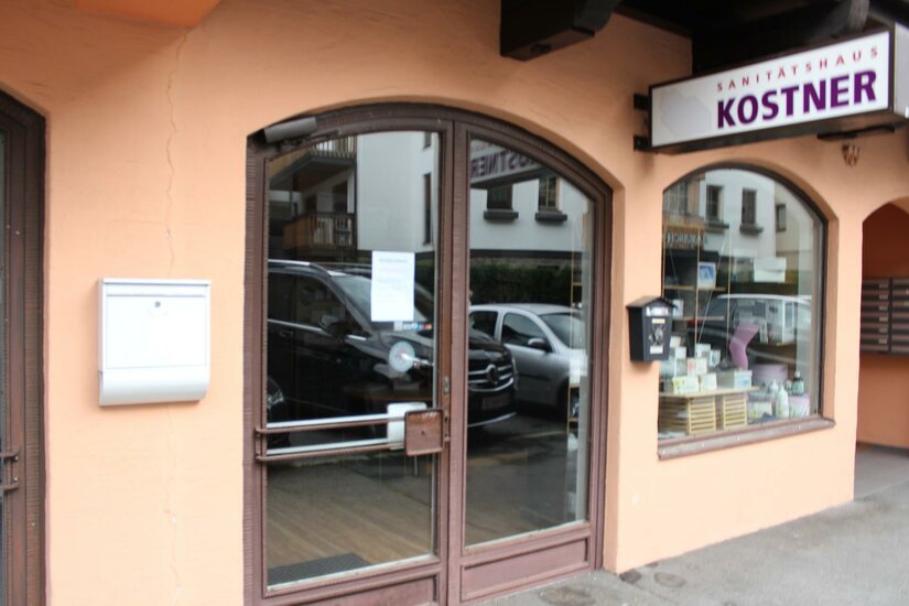 Kostner Ein Geschäft mit einer Eingangstür und Fenstern. Über der Tür steht der Schriftzug "KOSTNER".
