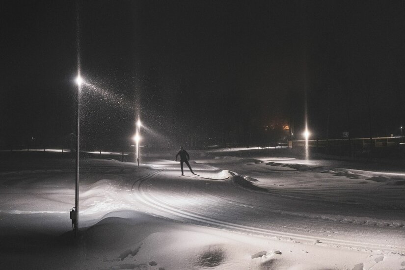 Nachtloipe Kitzbühel-Schwarzsee-Reith Person beim Skilanglauf auf einer beleuchteten Nachtloipe bei Dunkelheit.