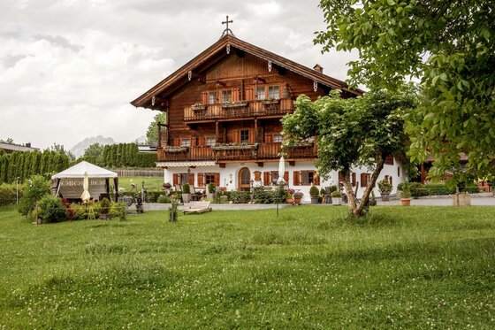 Bauernhof Astlingerhof Traditionelles Bauernhaus aus Holz mit Blumenbalkonen und großem Garten.