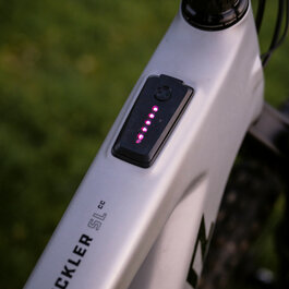 An e-bike with a modern design featuring a digital display with bright LEDs on the frame.