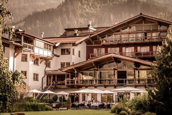 Außenansicht Terrasse 2 Hotel Kitzhof Ein charmantes Hotel in den Bergen mit einer einladenden Terrasse. Wunderschöne Natur umgibt die Gebäude.