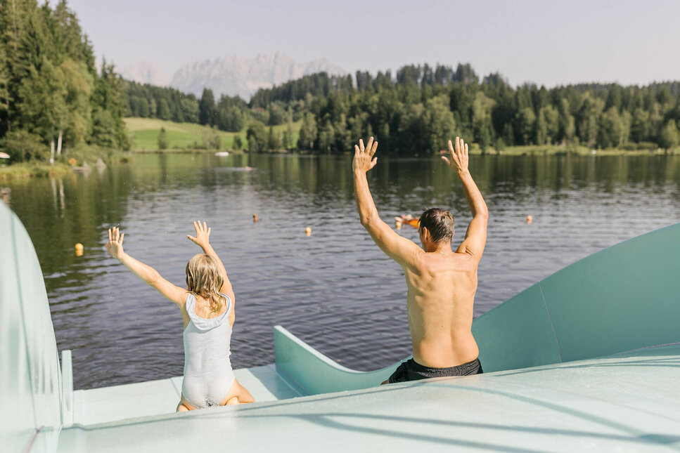 A family slides down a water slide at Schwarzsee in Kitzbühel