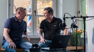 Two men in front of the window