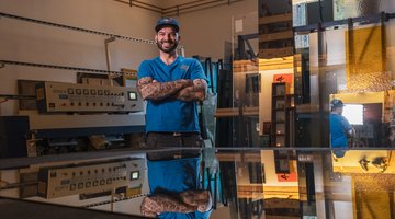 Ein Glasermeister steht in seiner Werkstatt