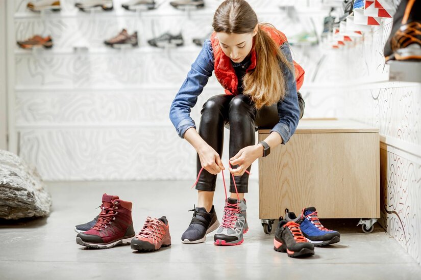 Schuhkauf bei Sport Noichl Eine Frau probiert in einem Sportgeschäft verschiedene Wanderschuhe an.