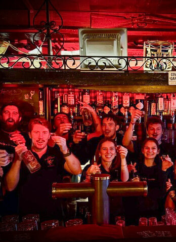 Menschen jubeln hinter der bar im The Londoner Kitzbühel