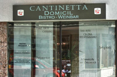 Außenansicht der Cantinetta Domicil Bistro und Weinbar mit beschrifteter Glasfront.