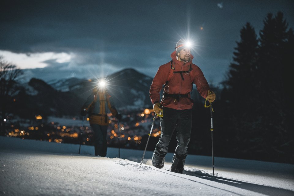 Zwei Skitourengeher mit Stirnlampe