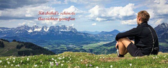 Aussicht vom Blaufeld Ein Wanderer sitzt auf einer Bergwiese und blickt auf das Bergmassiv des Wilden Kaisers.