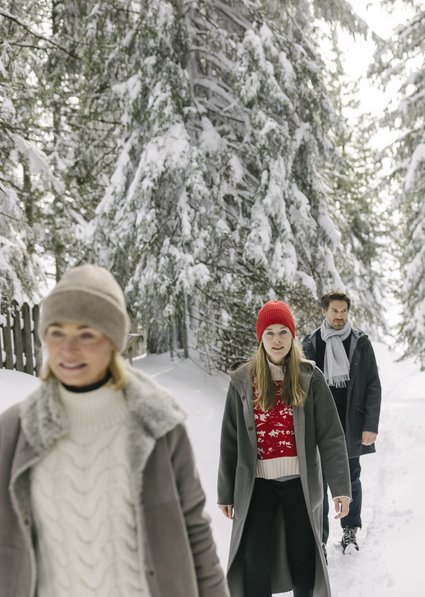 Gruppe beim Winterwandern im Wald am Hahnenkamm